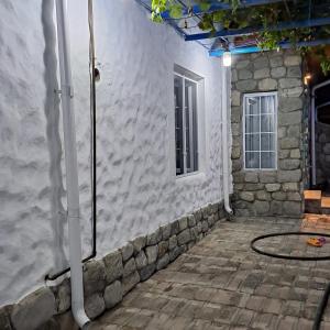 a patio with a stone wall and a window at İvanovka Boutique House in İsmayıllı
