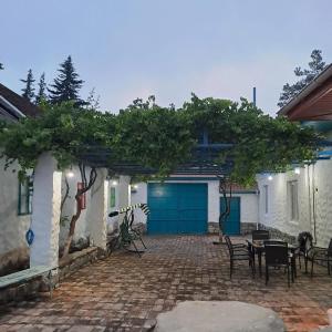 a patio with a blue door and a table and chairs at İvanovka Boutique House in İsmayıllı