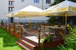 eine Terrasse mit Sonnenschirmen, Tischen und Stühlen in der Unterkunft Hotel Biograf in Písek