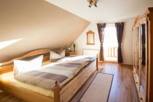ヘリングスドルフにあるHaus Jennyの屋根裏に大きな木製ベッドが備わるベッドルーム1室が備わります。