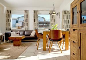 sala de estar con mesa, sillas y sofá en Ferienhaus Fietje, en Zinnowitz
