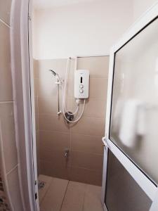 a shower in a bathroom with a glass door at Izmira Serviced Apartment Studio in Mombasa