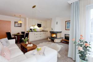 ein Wohnzimmer mit einer weißen Couch und einem Kamin in der Unterkunft Residenz Bismarck in Ahlbeck