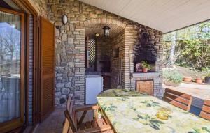 a patio with a table and a stone wall at Villa Paradiso by PosarelliVillas in Nestore