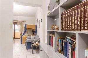 a hallway with bookshelves and a room with a bed at Alexander Beach Hotel in Kalamaki