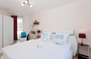 ヘリングスドルフにあるVilla Bettinaの白いベッドルーム(青い枕の白いベッド付)