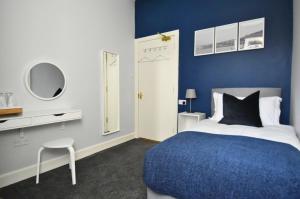a blue and white bedroom with a bed and a chair at Exclusive Use in Gourock