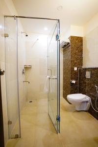 uma casa de banho com uma cabina de duche em vidro e um WC. em Hotel Northwind Mohali em Mohali