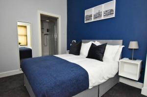 a bedroom with a large bed with blue walls at Exclusive Use in Gourock