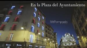 潘普洛納的住宿－Hotel Pompaelo Plaza del Ayuntamiento & Spa，夜幕降临的城市街道上一座高楼