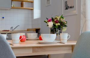 einen Tisch mit Tassen und eine Vase Blumen drauf in der Unterkunft Villa Frisia Nr 29 in Bansin