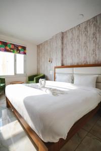 sypialnia z dużym łóżkiem z białą pościelą w obiekcie Hotel Northwind Mohali w mieście Mohali