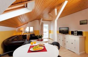 una sala de estar con una mesa con fruta. en Villa Helene - Appartement 6 en Heringsdorf