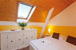 1 dormitorio con cama blanca y ventana en Villa Helene - Appartement 6 en Heringsdorf