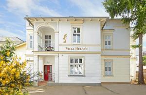 un edificio blanco con un cartel que lee Villa Heinemann en Villa Helene - Appartement 6 en Heringsdorf