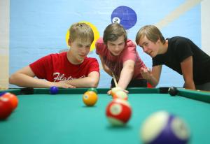 Drei junge Männer spielen Billard in der Unterkunft Jugendherberge Lübeck Vor dem Burgtor in Lübeck