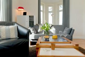 een woonkamer met een bank en een tafel met wijnglazen bij Villa Gruner Nr 8 in Zinnowitz