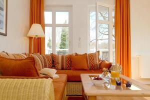 - un salon avec un canapé orange et une table dans l'établissement Villa Gruner Nr 18, à Zinnowitz