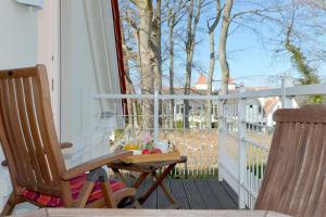 - une terrasse couverte avec 2 chaises et une table sur un balcon dans l'établissement Villa Gruner Nr 18, à Zinnowitz