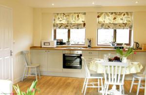 a kitchen with a table and a table and chairs at Goldridge in Alton