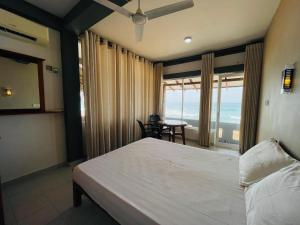a bedroom with a bed and a view of the ocean at Hotel Apollo in Hikkaduwa