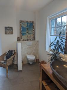 La salle de bains est pourvue de toilettes et d'un lavabo. dans l'établissement Ferienhaus Seestern in Reinbek, à Reinbek