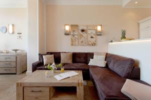 ein Wohnzimmer mit einem braunen Ledersofa und einem Tisch in der Unterkunft Villa Louise Nr 6 in Ahlbeck