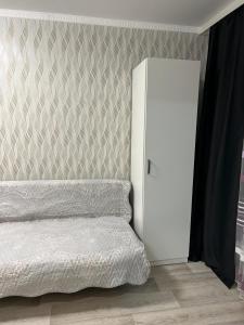 a bedroom with a bed and a white refrigerator at Двухкомнатная квартира в городе Экибастуз in Ekibastuz