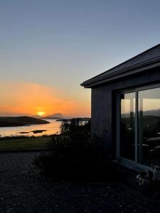 una casa con il tramonto sullo sfondo di Sandhill, a Mulranny