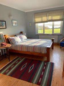 una camera con letto, finestra e tappeto di Sandhill, a Mulranny