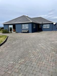 una casa blu con una panchina davanti di Sandhill, a Mulranny