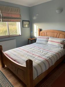 een slaapkamer met een groot bed met een houten hoofdeinde bij Sandhill, in Mulranny