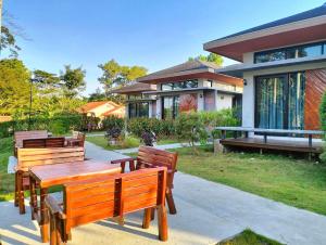 un grupo de bancos frente a una casa en ProudChan Boutique Resort en Chanthaburi