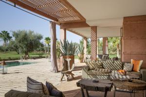 a patio with couches and chairs and a pool at Villa MISH-MISH in Marrakesh