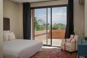 a bedroom with a bed and a sliding glass door at Villa MISH-MISH in Marrakesh