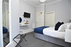 a bedroom with a bed and a desk and a television at The Shore in Gourock