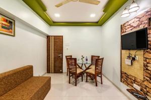 a dining room with a table and chairs and a flat screen tv at Retreat Heritage in Lonavala