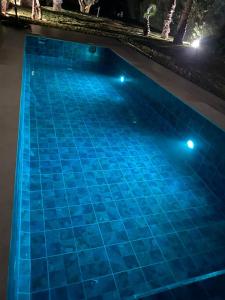 una piscina por la noche con luces azules en Villa Firdaous, en Marrakech