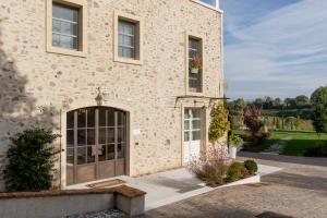 a stone house with a door and a yard at Relais Ca' Morenica in Valeggio sul Mincio