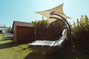 a chair in a yard with a umbrella at Agriturismo da Pudech in Ravenna