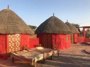 a group of huts with a bed in front at Osian Camel safari and Village home stay in Gheura
