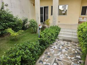a house with a stone walkway in front of a building at Guesthouse Cocotiers Cotonou in Cotonou