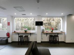 two bar stools in a room with two windows at Hotel Myro in Gijón