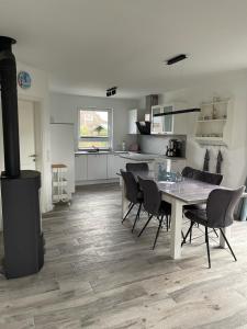 eine Küche und ein Esszimmer mit einem Tisch und Stühlen in der Unterkunft Ferienhaus Seepferd in Holnishof