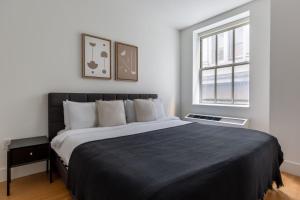 Un dormitorio con una cama grande y una ventana en FiDi 1br w gym doorman nr wall street NYC-1337 en Nueva York