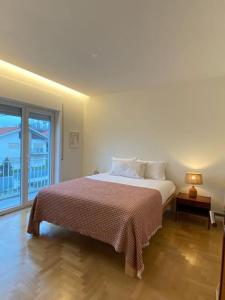 ein Schlafzimmer mit einem Bett und einem großen Fenster in der Unterkunft Porto Aldoar Boutique Flat (Inês) in Porto