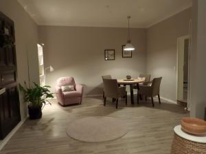 uma sala de estar com uma mesa e uma cadeira rosa em am Conradhof em Goch
