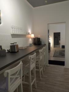 uma cozinha com um balcão e algumas cadeiras brancas em am Conradhof em Goch