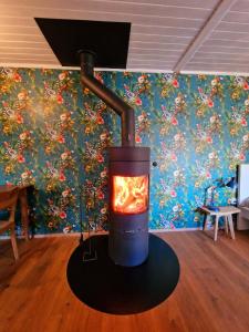 a wood stove with a fire in a room at Kunstplanet im Herzen der Alpen am Planetenweg in Visp