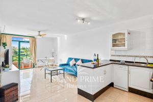 a kitchen and living room with a blue couch at Golf and Sea Views Holiday in Golf del Sur in San Miguel de Abona